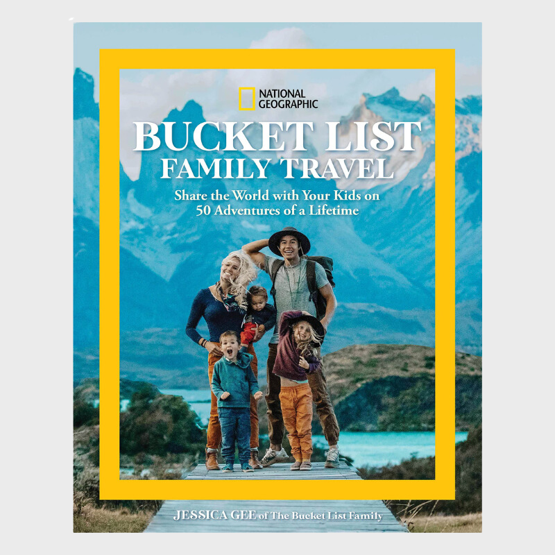 An image of the book cover of National Geographic Bucket List Family Travel. The book cover is of The Bucket List Family on a dock in front of a lake and mountains.