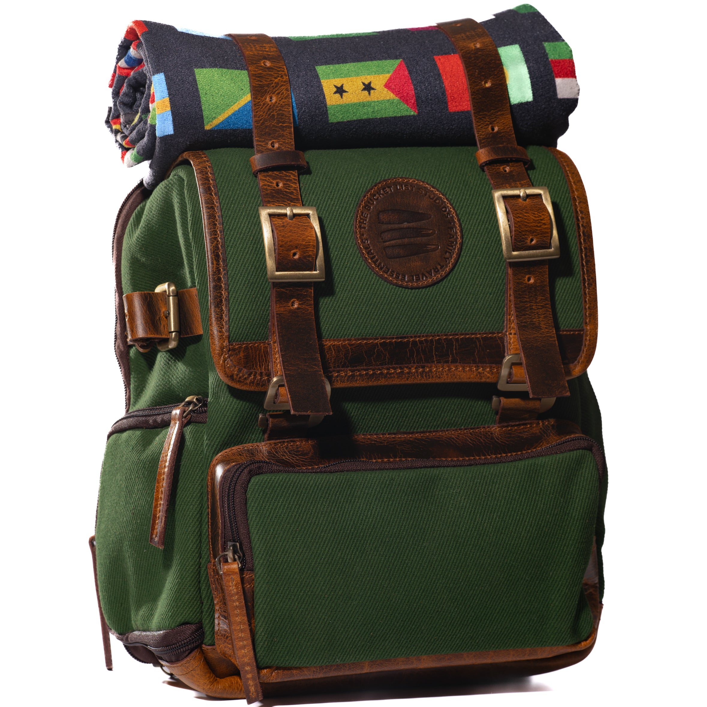 Product photo of a green canvas and leather backpack with a black rolltop blanket on top of the backpack.