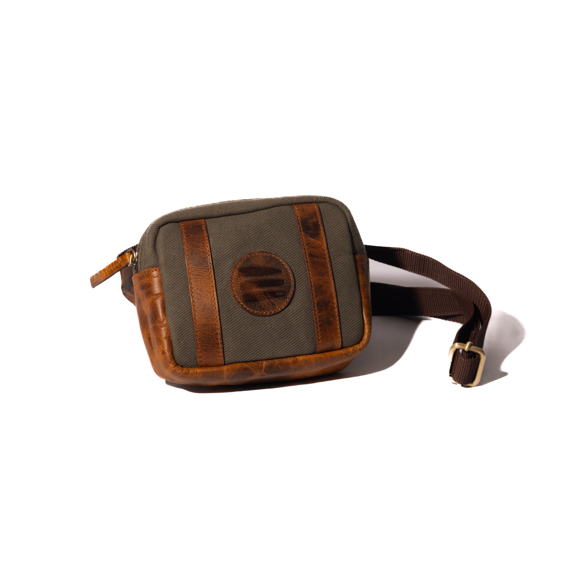 Product photo of a vintage sage canvas and leather belt bag with a white background.