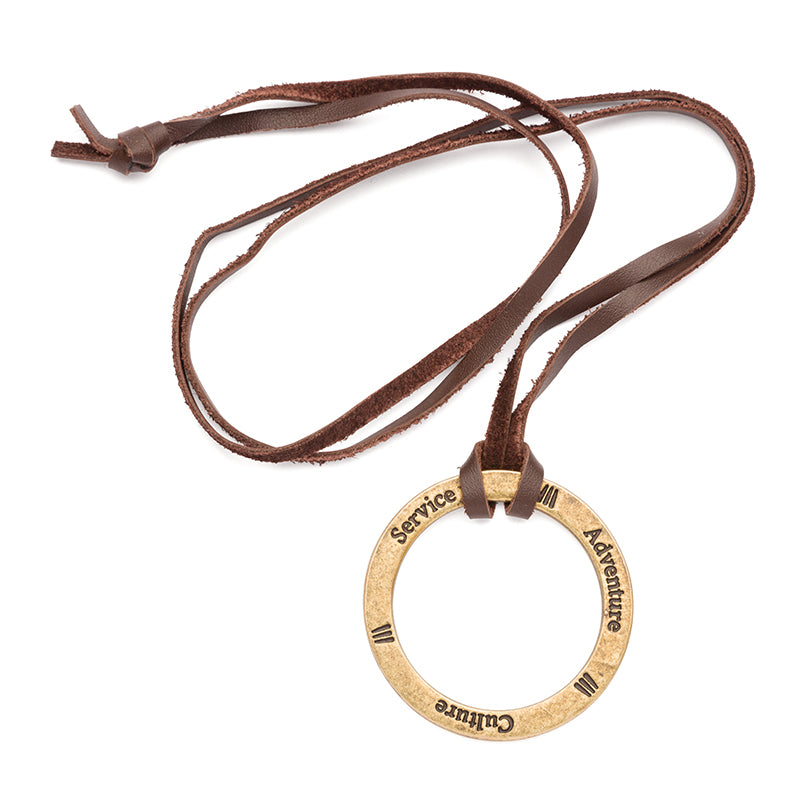 Product photo with a white background of a necklace with a brown leather band and a metal ring that has the words service, adventure, and culture engraved on it.