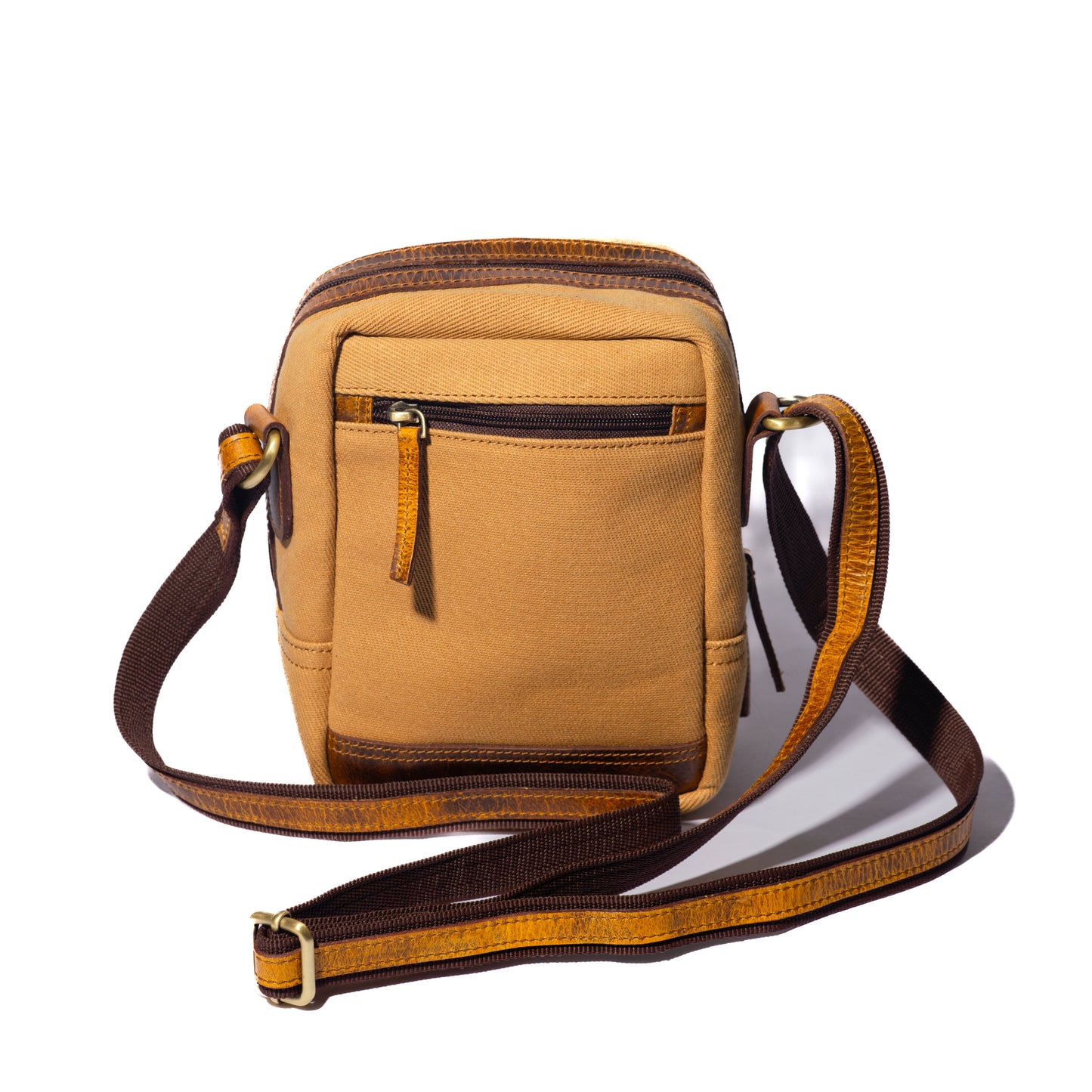 Product photo of the back of a tan sling pouch with a white background.