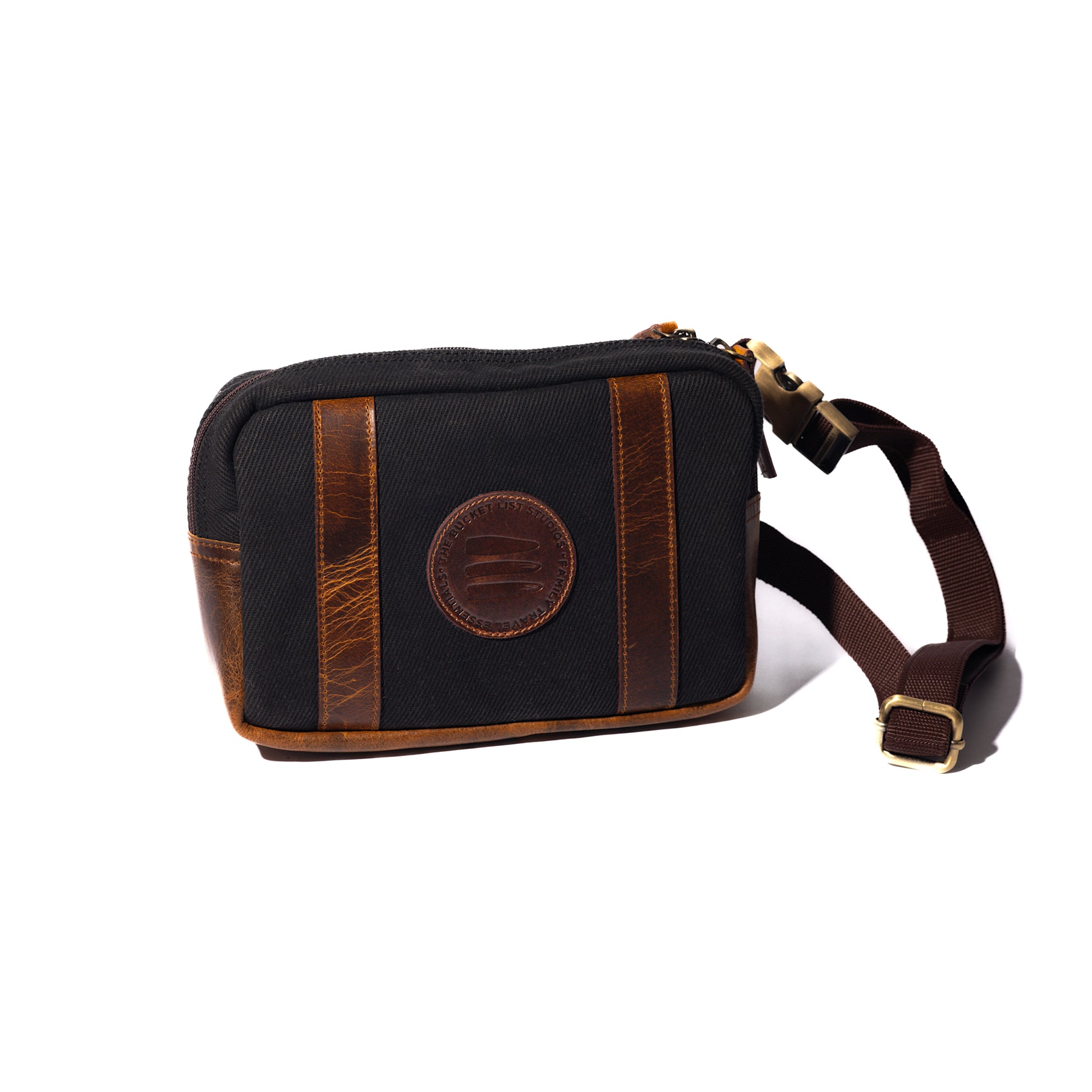 Product image of a black canvas and leather crossbody belt bag with a white background. 