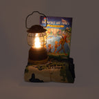 Lighted lantern next to a children's book on a dark background
