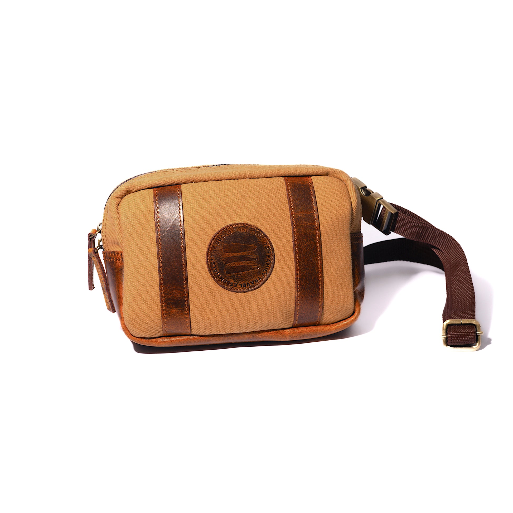 Product image of a tan canvas and leather crossbody belt bag with a white background. 