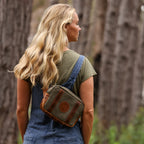 Photo of the back of woman with blonde hair wearing a vintage sage crossbody bag across her back. 
