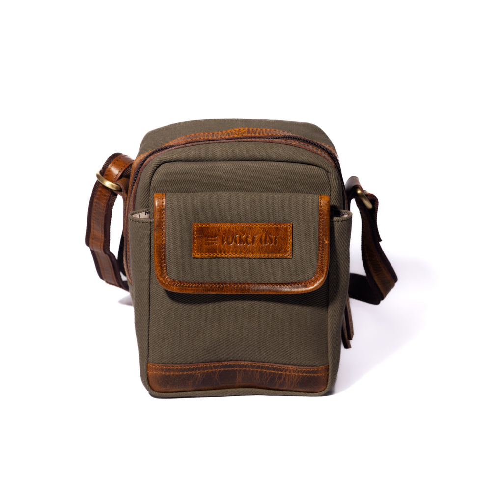 Product photo of a vintage sage sling pouch with a white background.