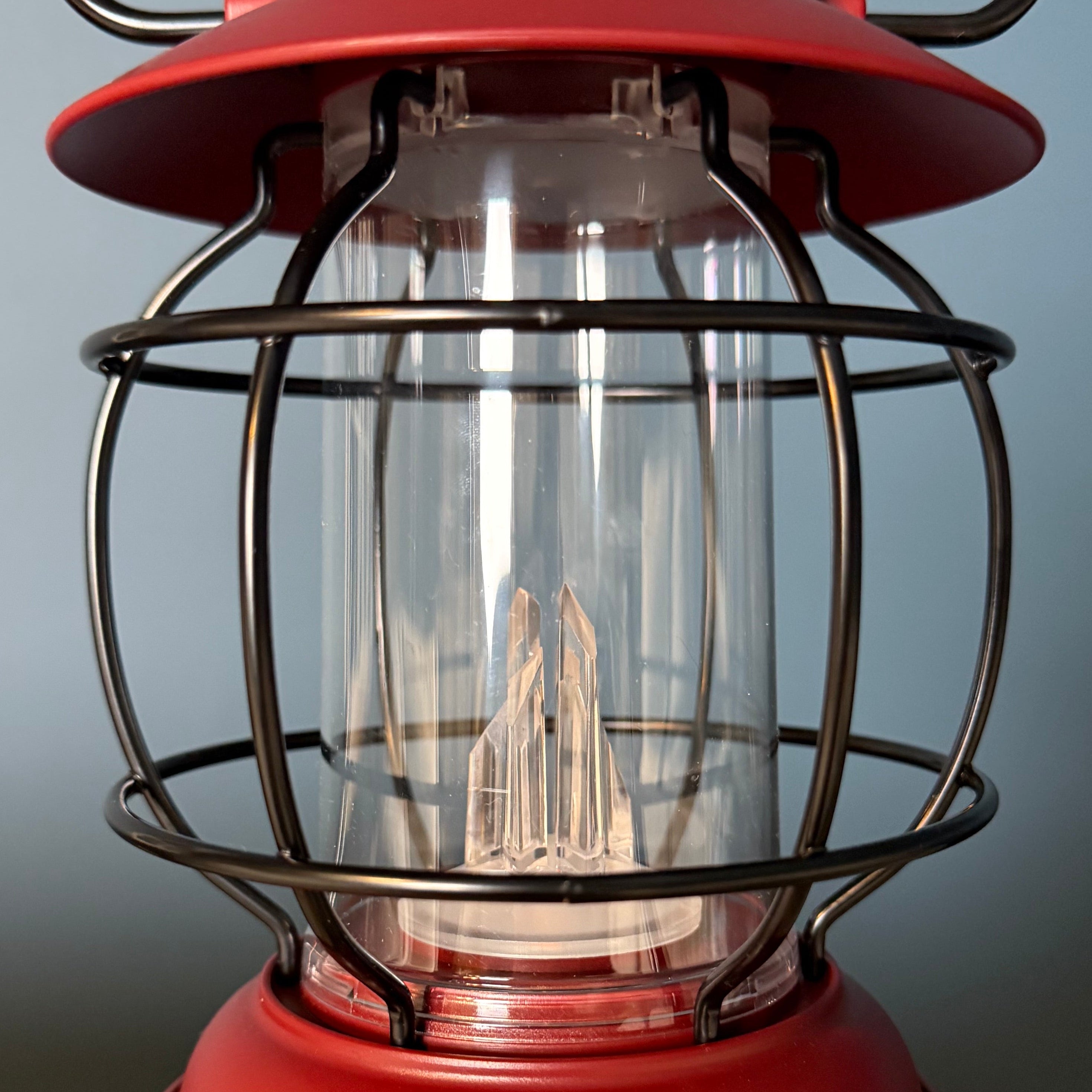 Red lantern with a clear glass cover on a textured surface