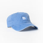 Product photo with a white background of a light blue baseball cap with a white embroidered bucket list logo on the front center. 