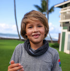 Picture of a boy wearing a black and grey buff around his neck. 