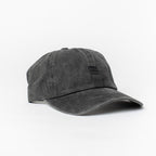 Product photo with a white background of a black baseball cap with a black embroidered bucket list logo on the front of the cap. 